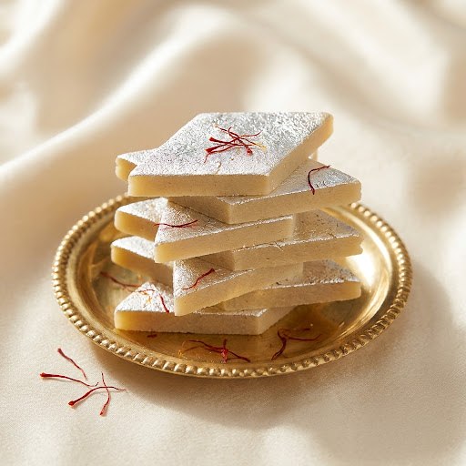 Kaju Katli, diamond-cut cashew fudge with silver leaf on a brass plate